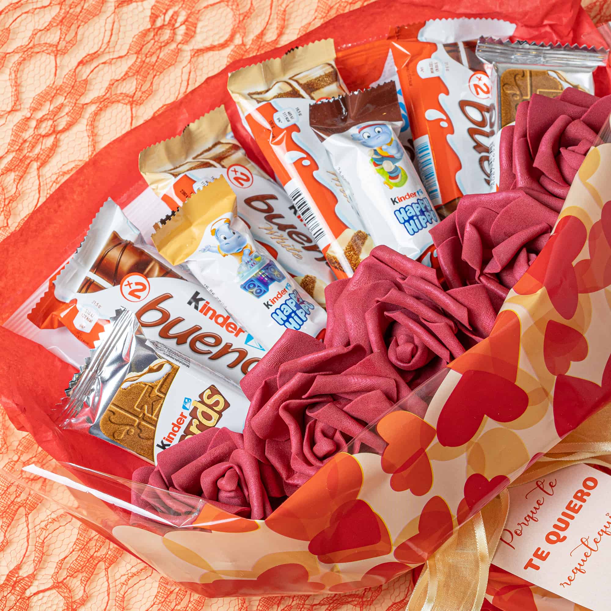 Detalle romántico con chocolates Kinder Bueno y rosas decorativas.