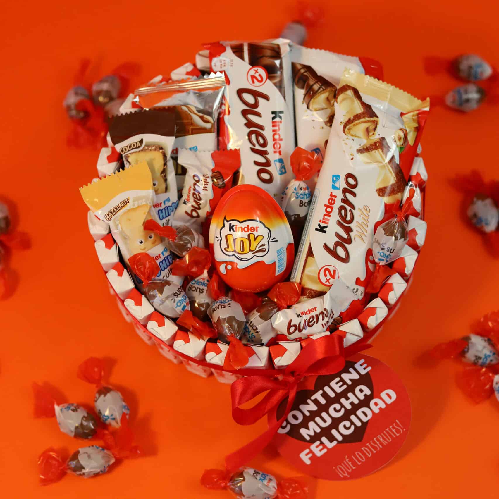 Cesta de chocolates Kinder con lazo rojo decorativo.