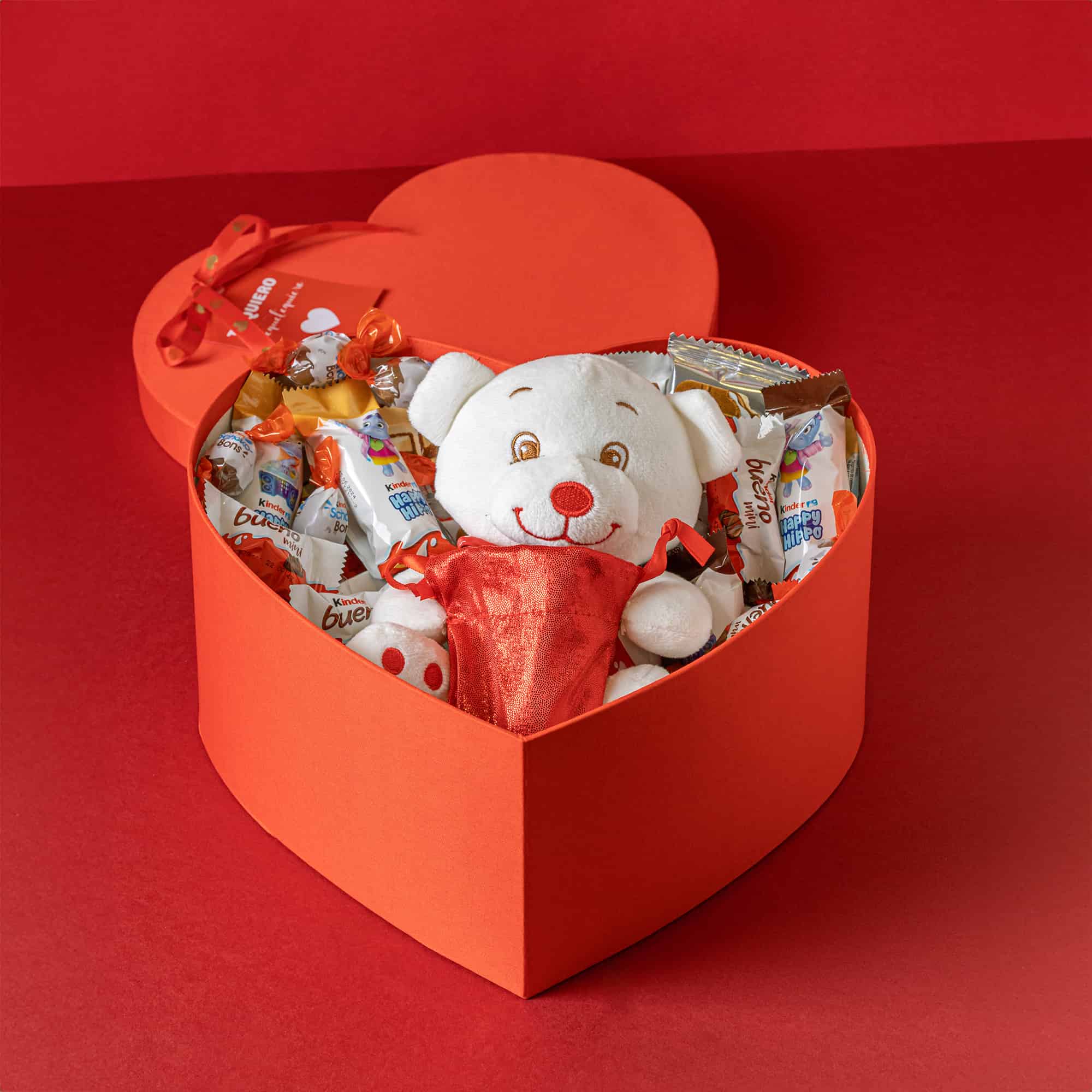Regalo romántico con surtido Kinder y un adorable oso de peluche.

