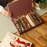 Caja regalo en forma de libro de Papá Noel con surtido de frutos secos bañados en chocolate