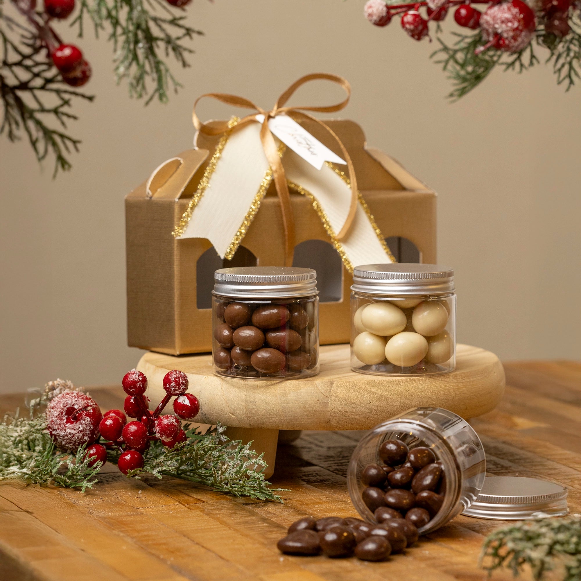 Cajita navideña dorada con tres botes de frutos secos bañados en chocolate