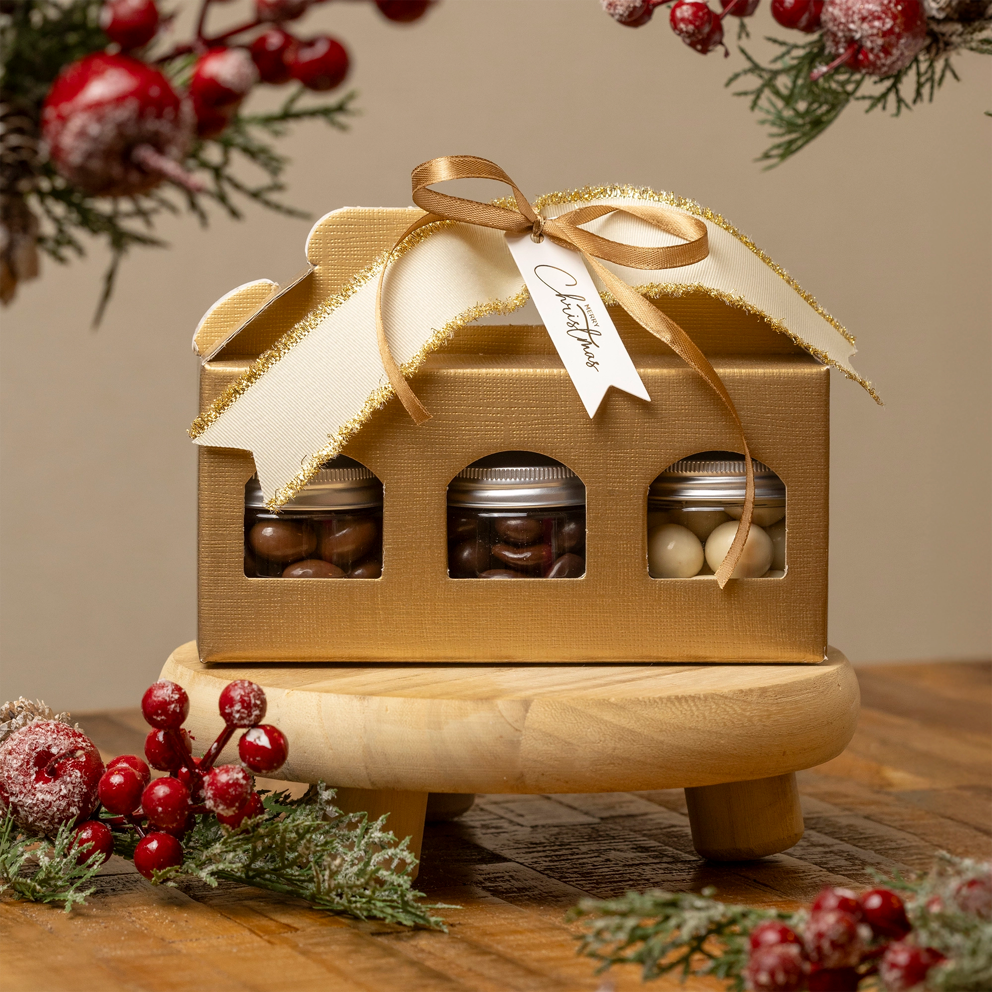 Cajita navideña dorada con lazos y etiquetas lista para regalar