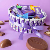 Cesta regalo con chocolates Milka y lazo lila.
