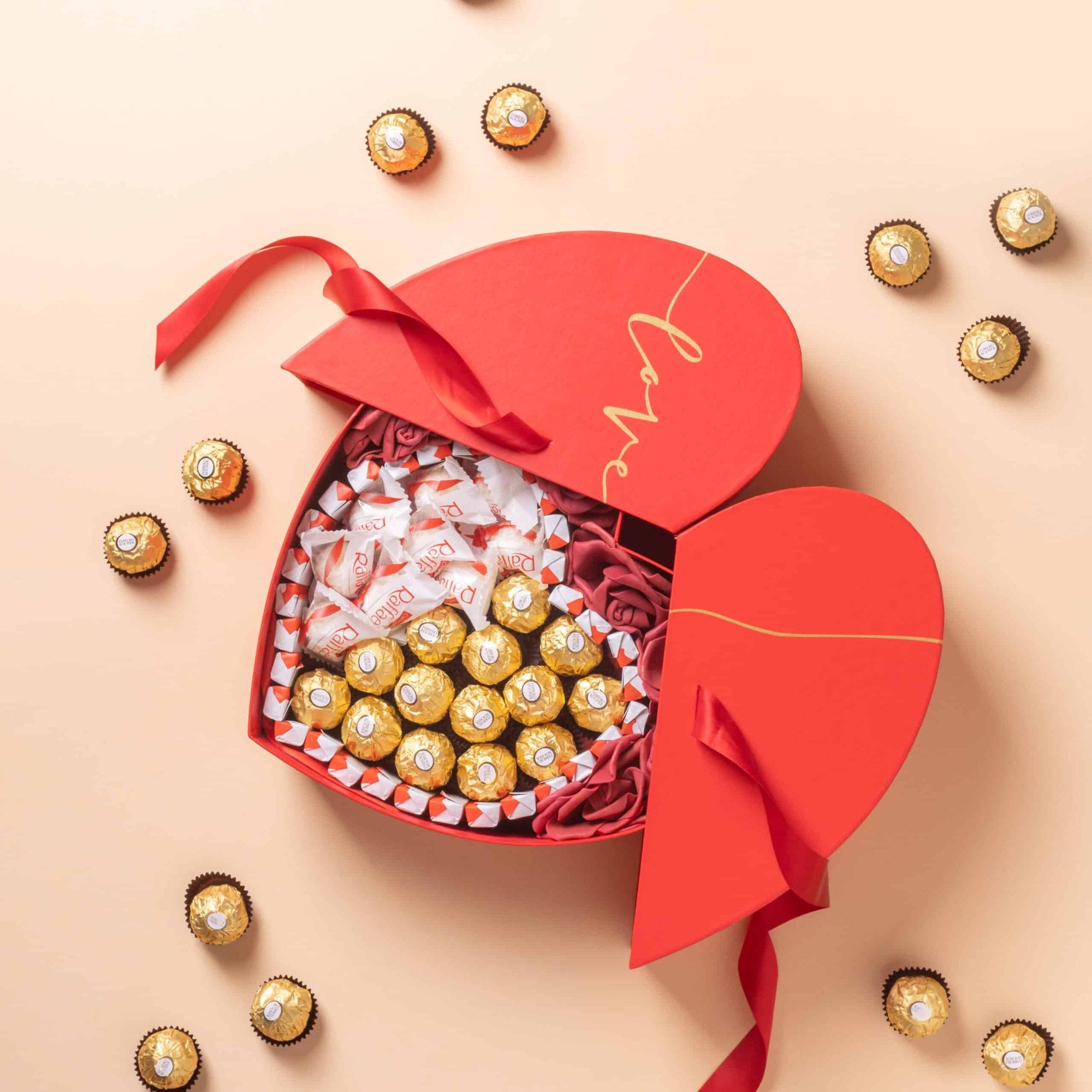 Caja de Corazón Premium Love rellena de bombones y rosas decorativas.
