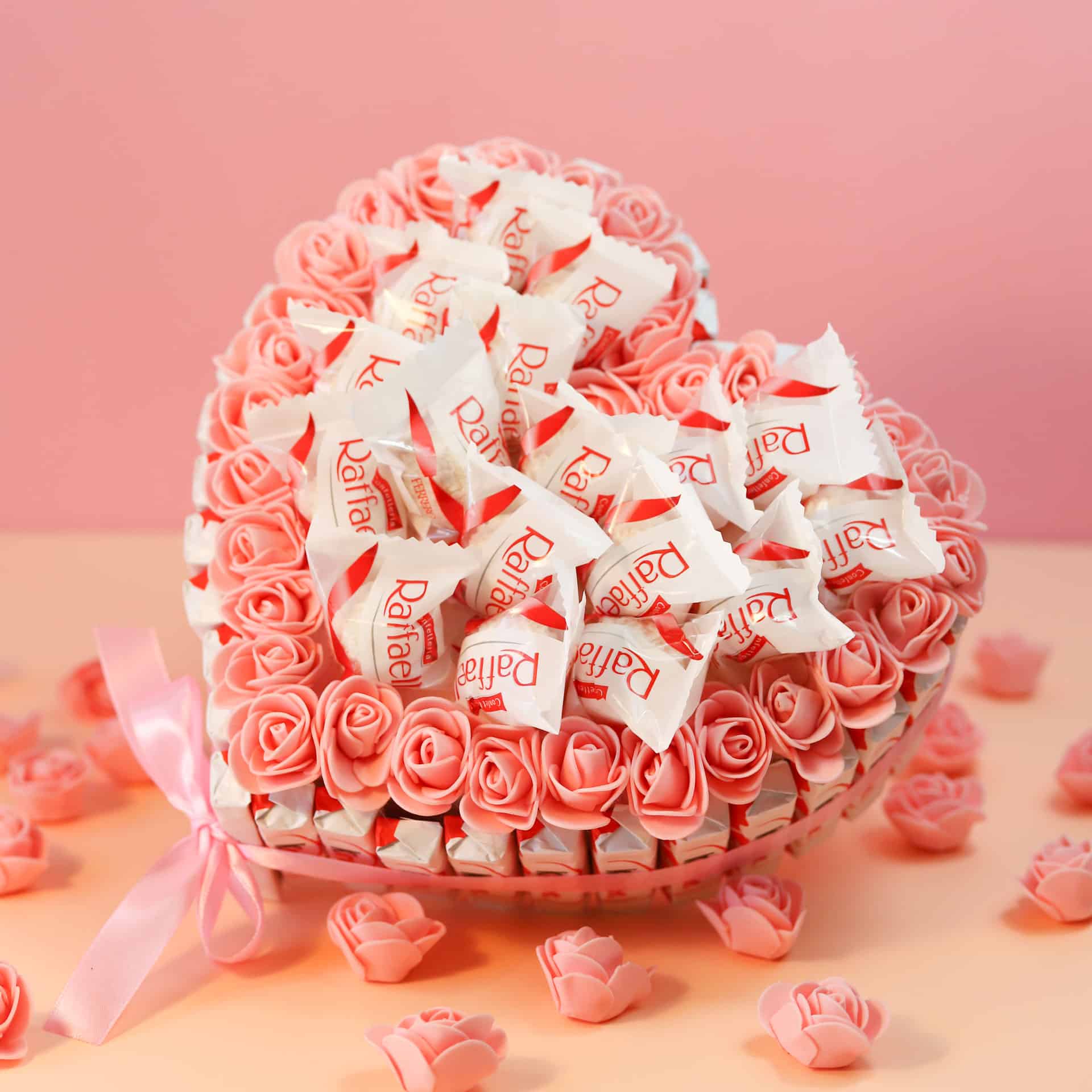 Tarta de corazón con bombones Raffaello y rosas decorativas.
